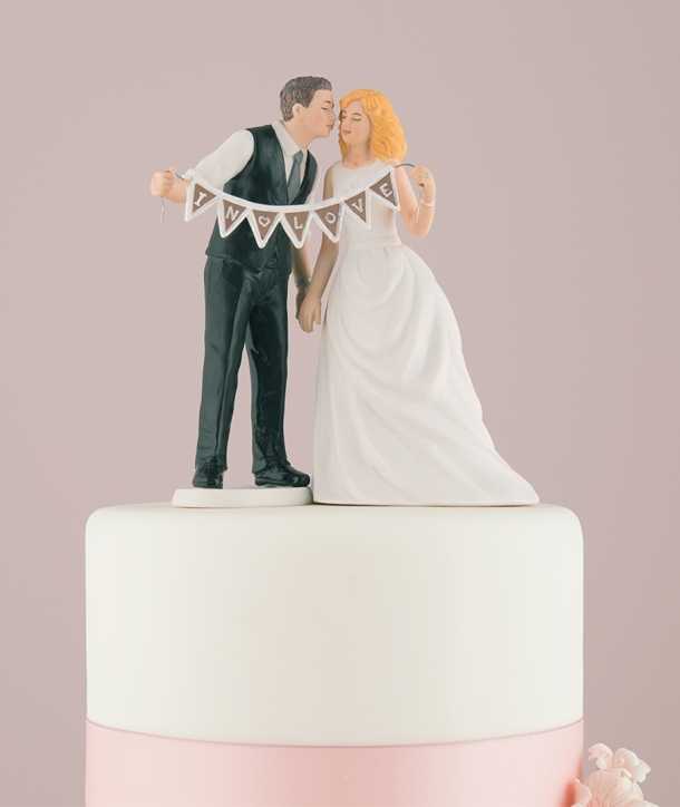 Figura de novios para tarta de bodas con banderín de enamorados